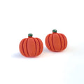 Pair of small handmade orange pumpkin-shaped stud earrings on a white background.