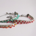 Three colourful bracelets in pale gold with rainbow bunting on a plain background.